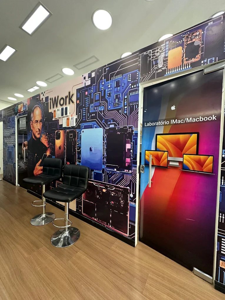 Interior da loja iWork em Santo Amaro, com parede ilustrada e laboratório de iMac e MacBook